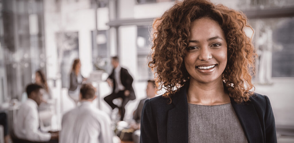 Mulher em um escritório sorrindo, representando o recrutamento de profissionais Efetivos